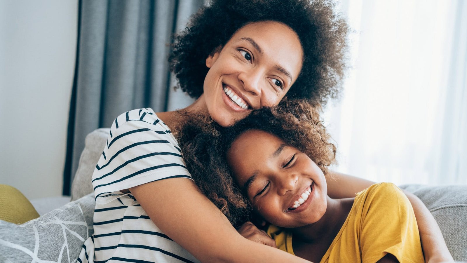 Mother and daughter hugging, smiling