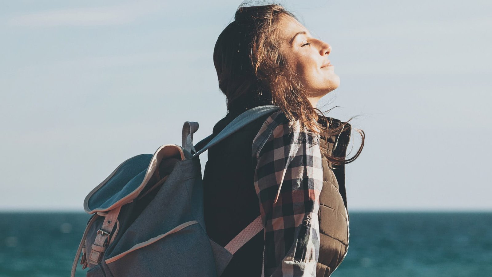 Woman smiling with her eyes closed outside
